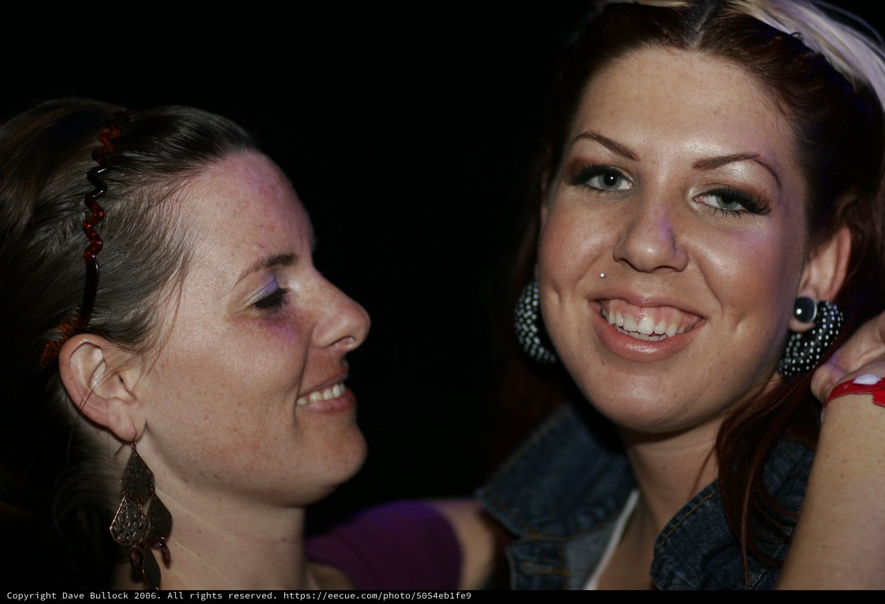 Two Friends Share a Joyful Moment at Night Event