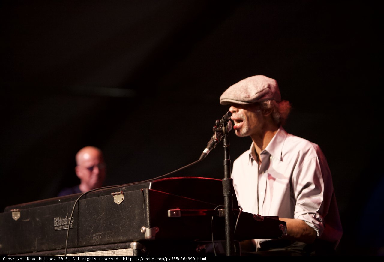 Hat-clad Man Rocks His Keyboard on Stage