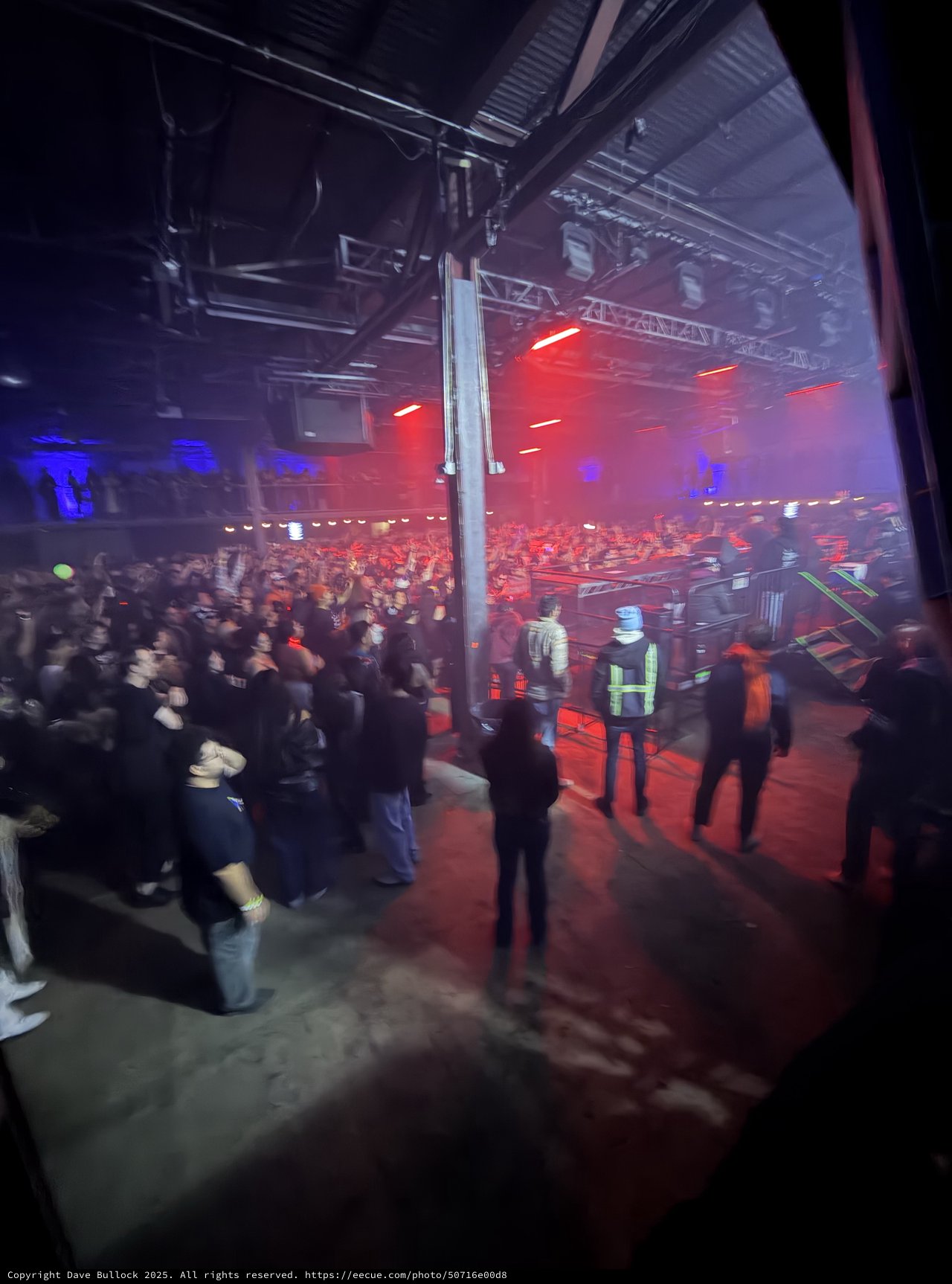 Red-Lit Industrial Warehouse Concert with Crowd and Security
