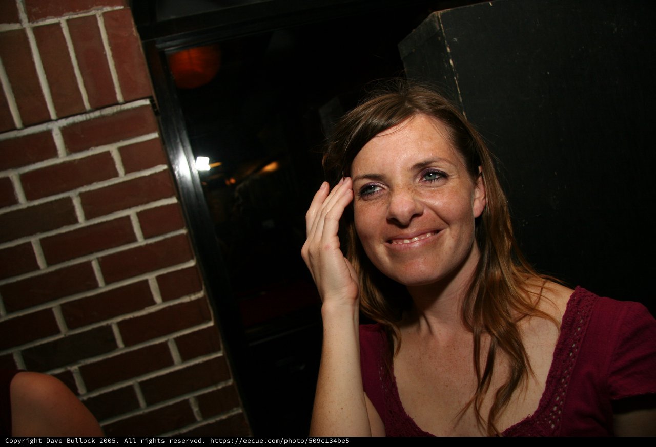 Candid Portrait of Smiling Woman in Dimly Lit Bar