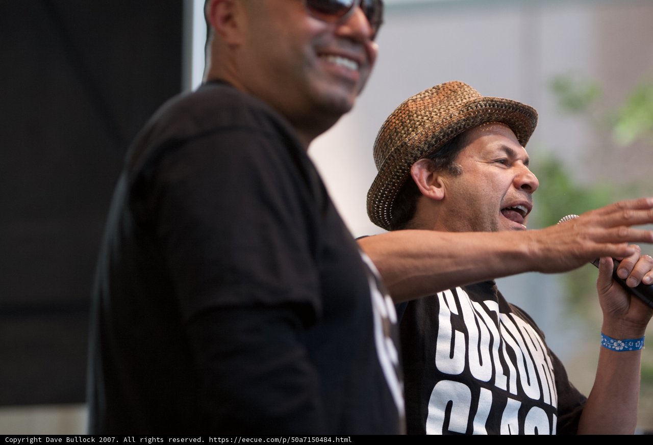 Two Men Hold Microphones with Smiling Faces