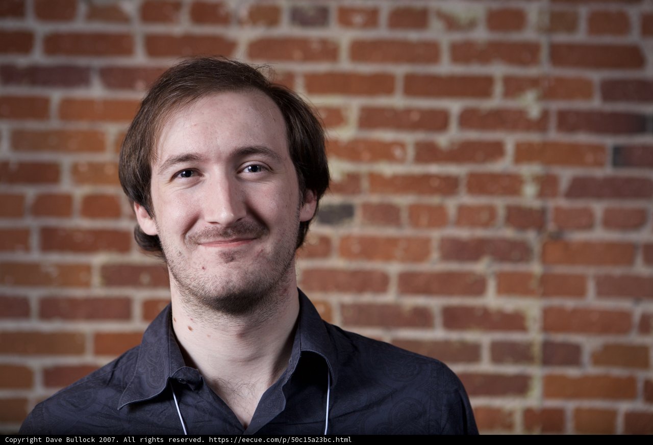 Happy Man Leaning Against Brick Wall