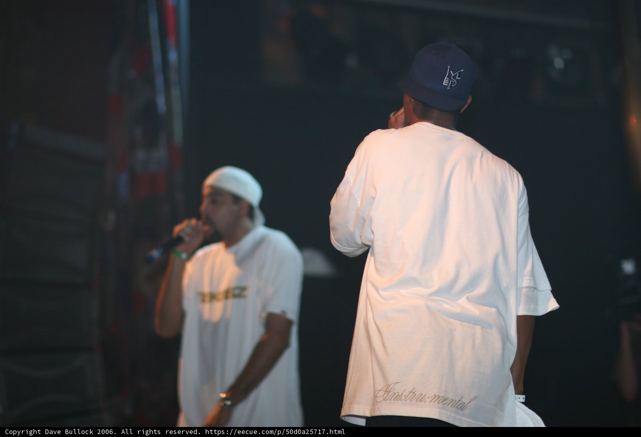 Two Men Perform on Stage with Baseball Caps