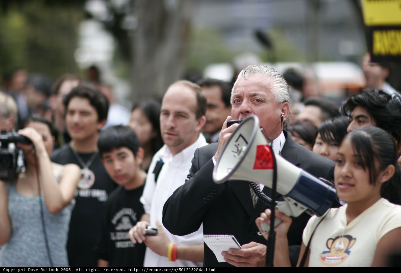 Advocating for Change Caption: He Zhuojia uses a megaphone to address the large crowd during the 2006 school walkout, urging them to stand up for their rights and demand change.