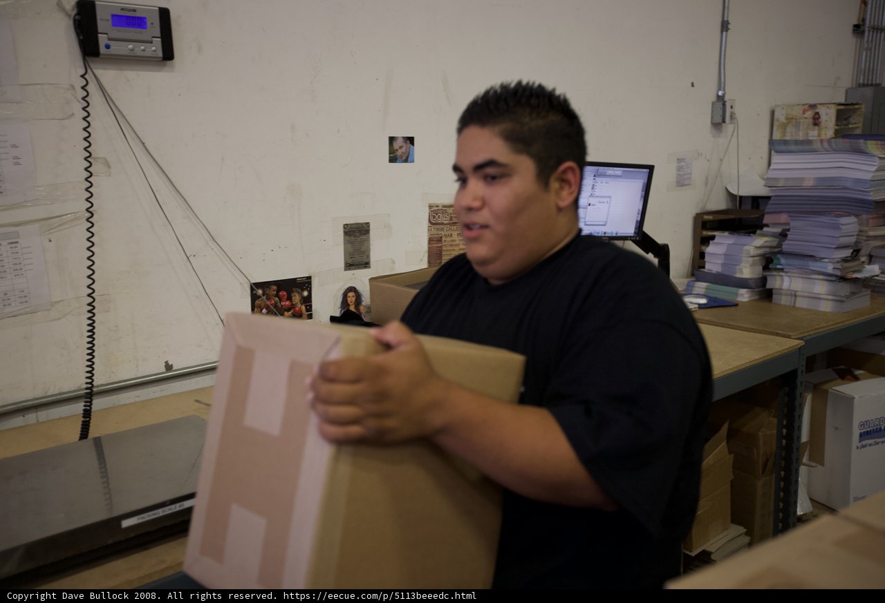 Man in Warehouse Holding Cardboard Boxes