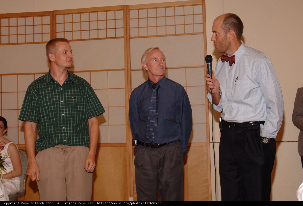 Three Men at Wedding Reception with Microphone