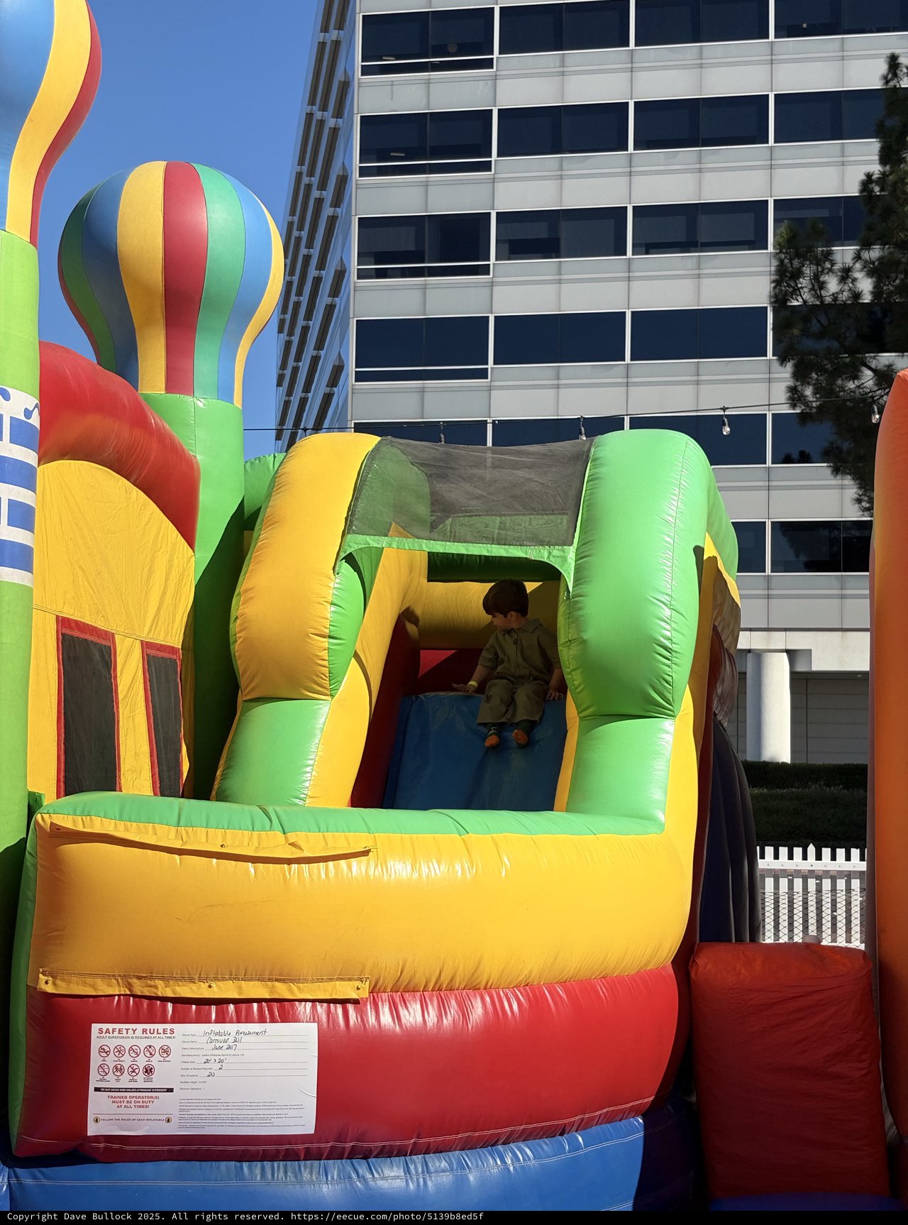 Child on Inflatable Bounce House Slide in Urban Setting