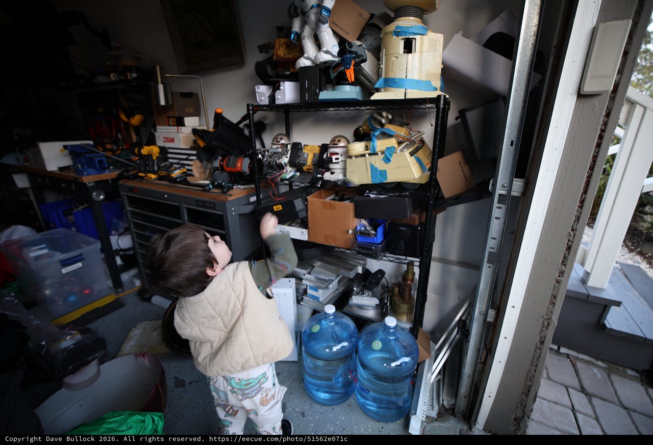 Young Child Exploring Workshop Storage Shelves