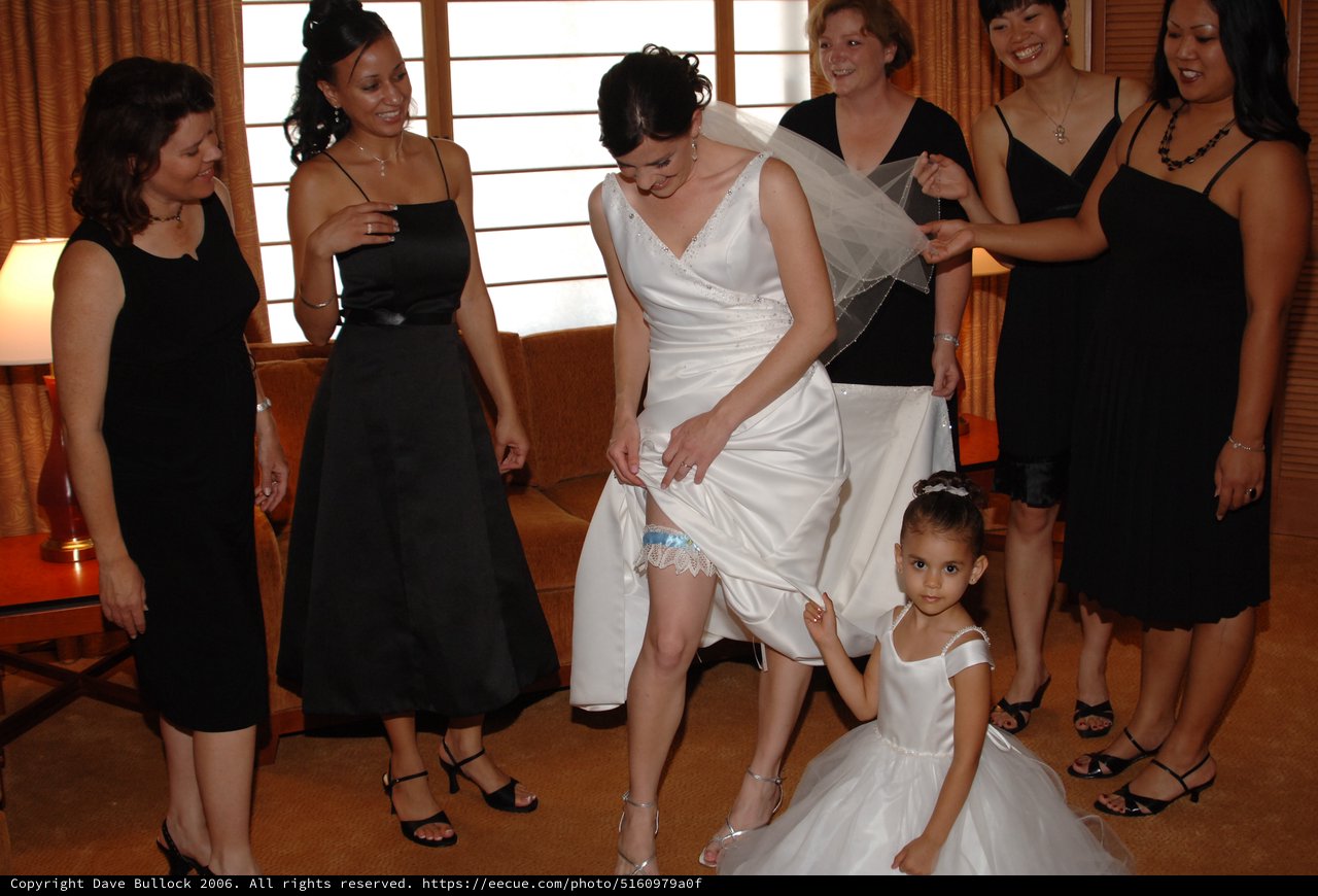 Bride Shows Off Wedding Garter with Bridesmaids