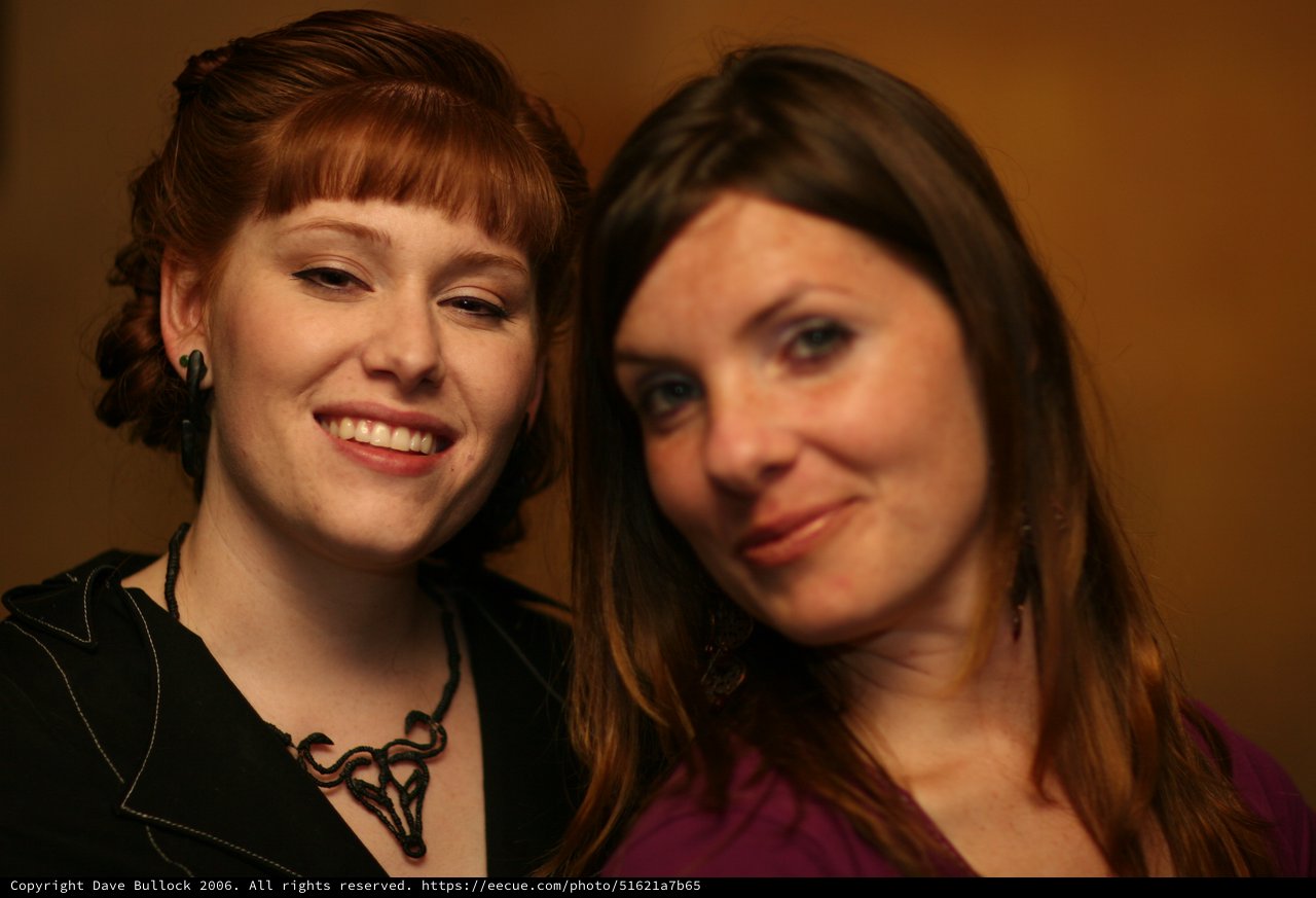 Two Women Smiling Together at Indoor Event
