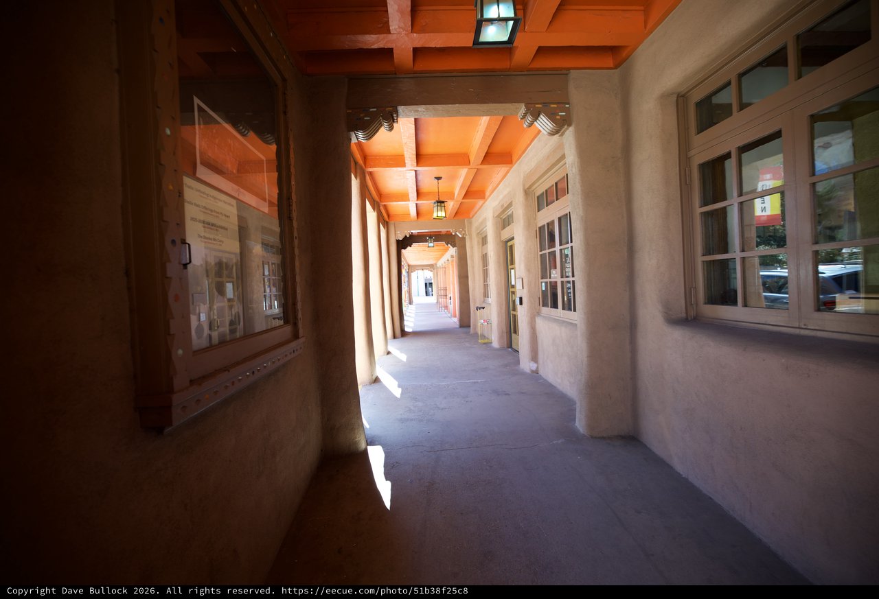 Sunlit Adobe Corridor with Wooden Beam Ceiling in Santa Fe