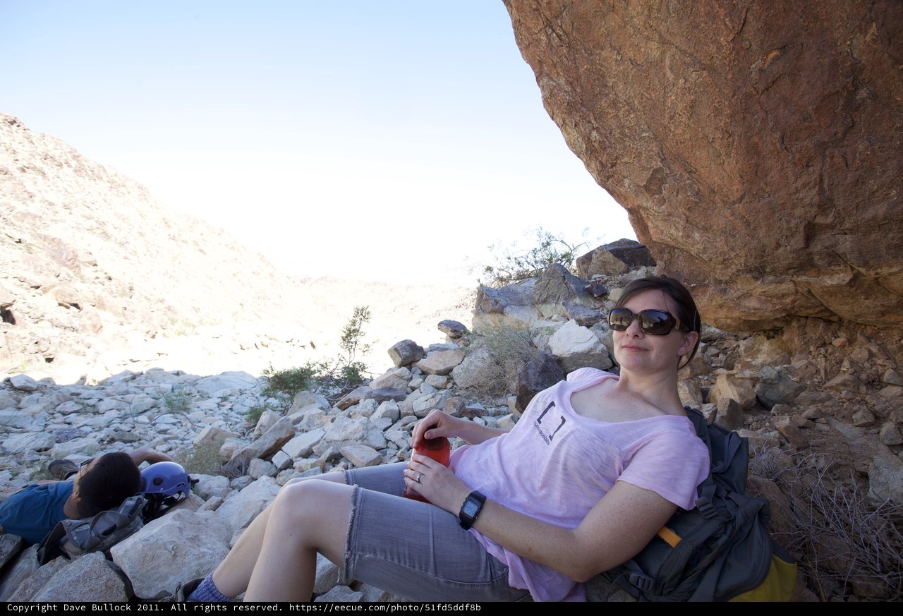 Desert Hiker Resting in the Shade of a Boulder