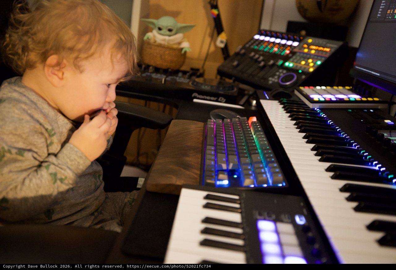 Young Child Explores Music Production Setup at Home