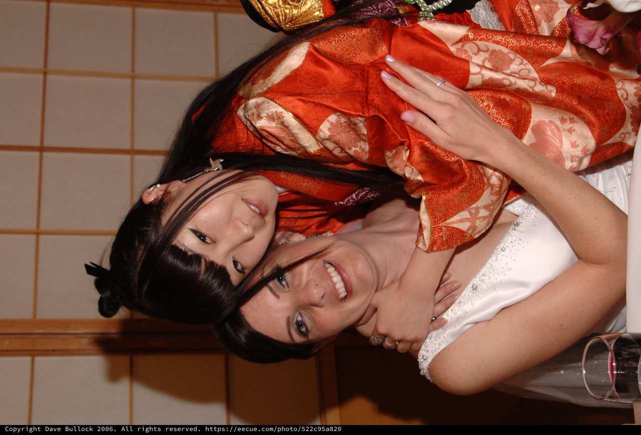 Two Women Embrace at Japanese-Themed Wedding Celebration
