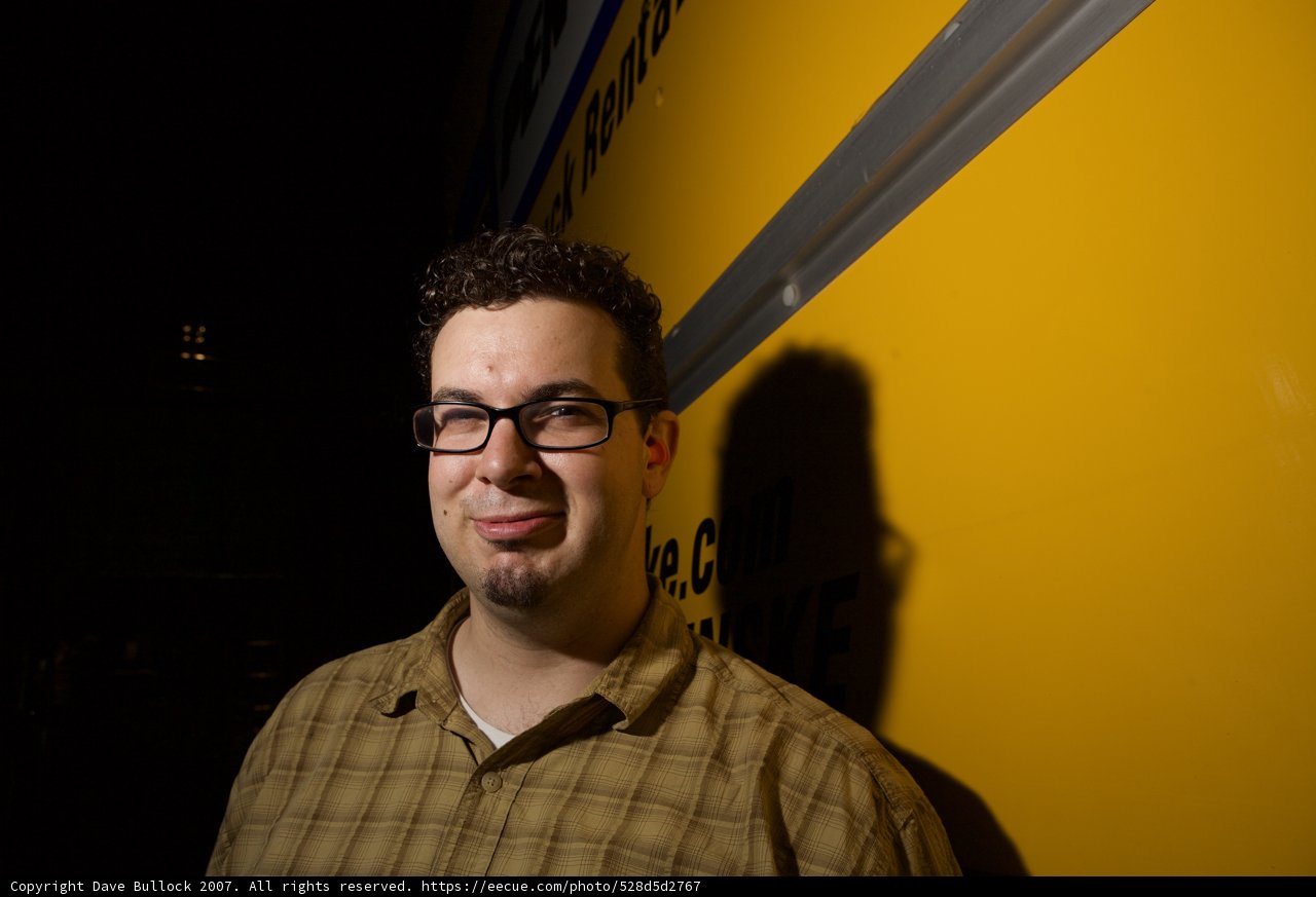 Dave B Smiling in Front of a Yellow Bus