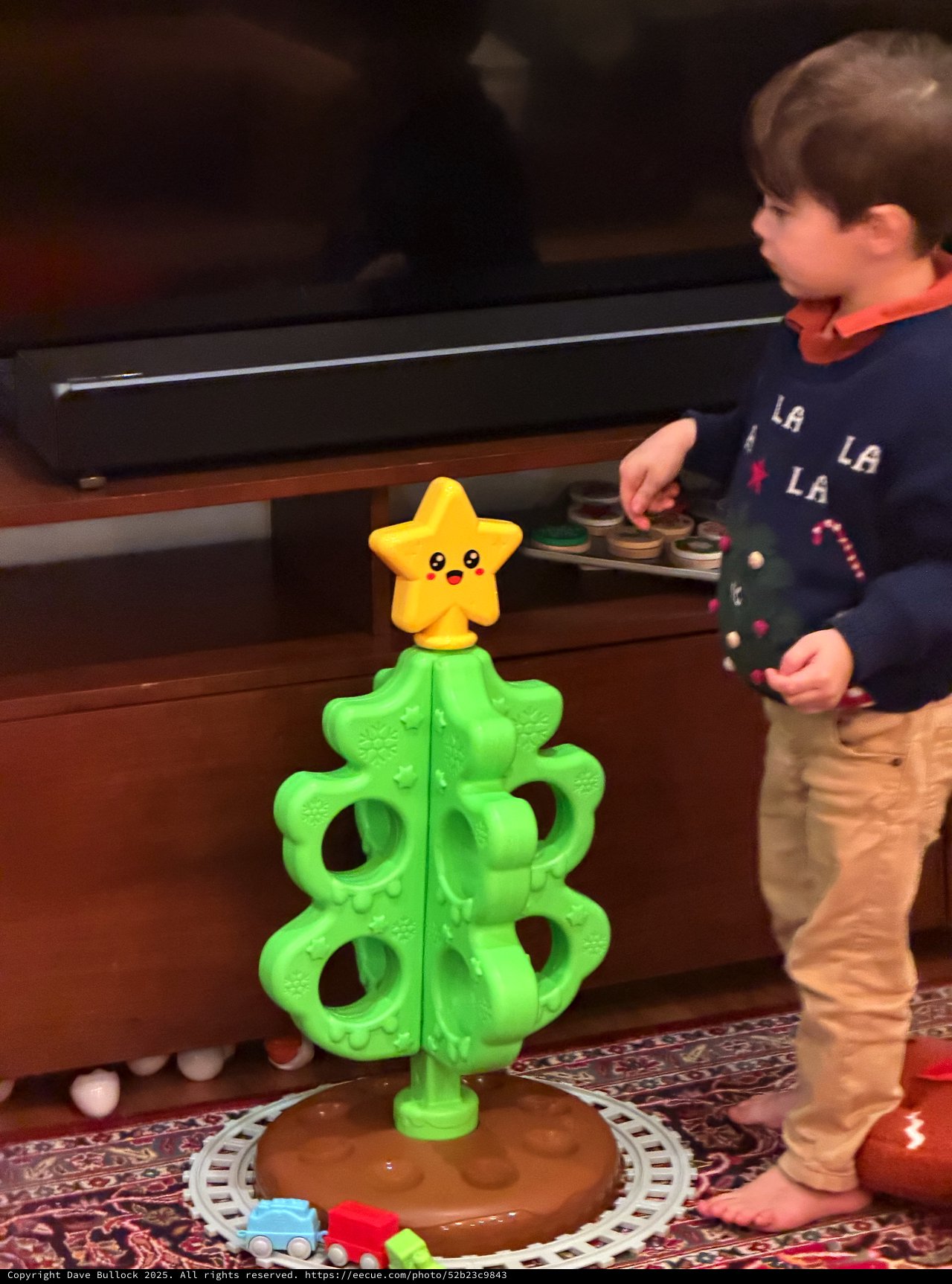 Child Playing with Christmas Tree Toy and Train Set