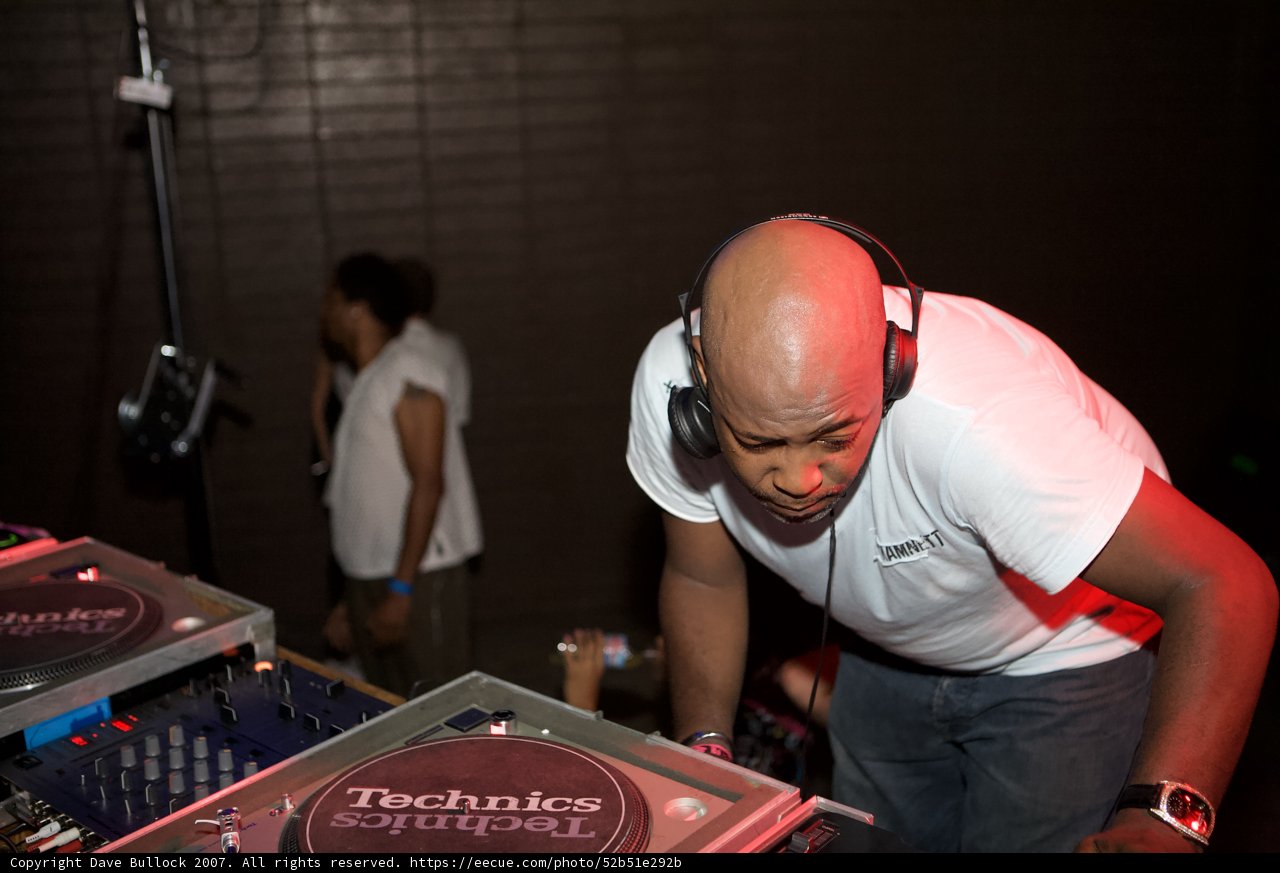 Groovy Deejay Mixing Music with Headphones at Party