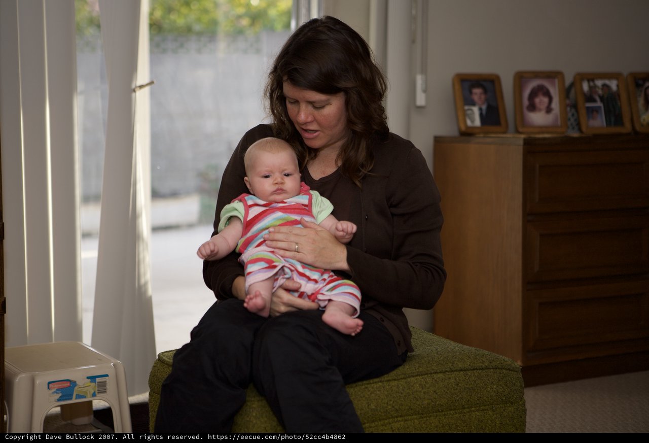 Mother Cradling Newborn Baby in Home Setting