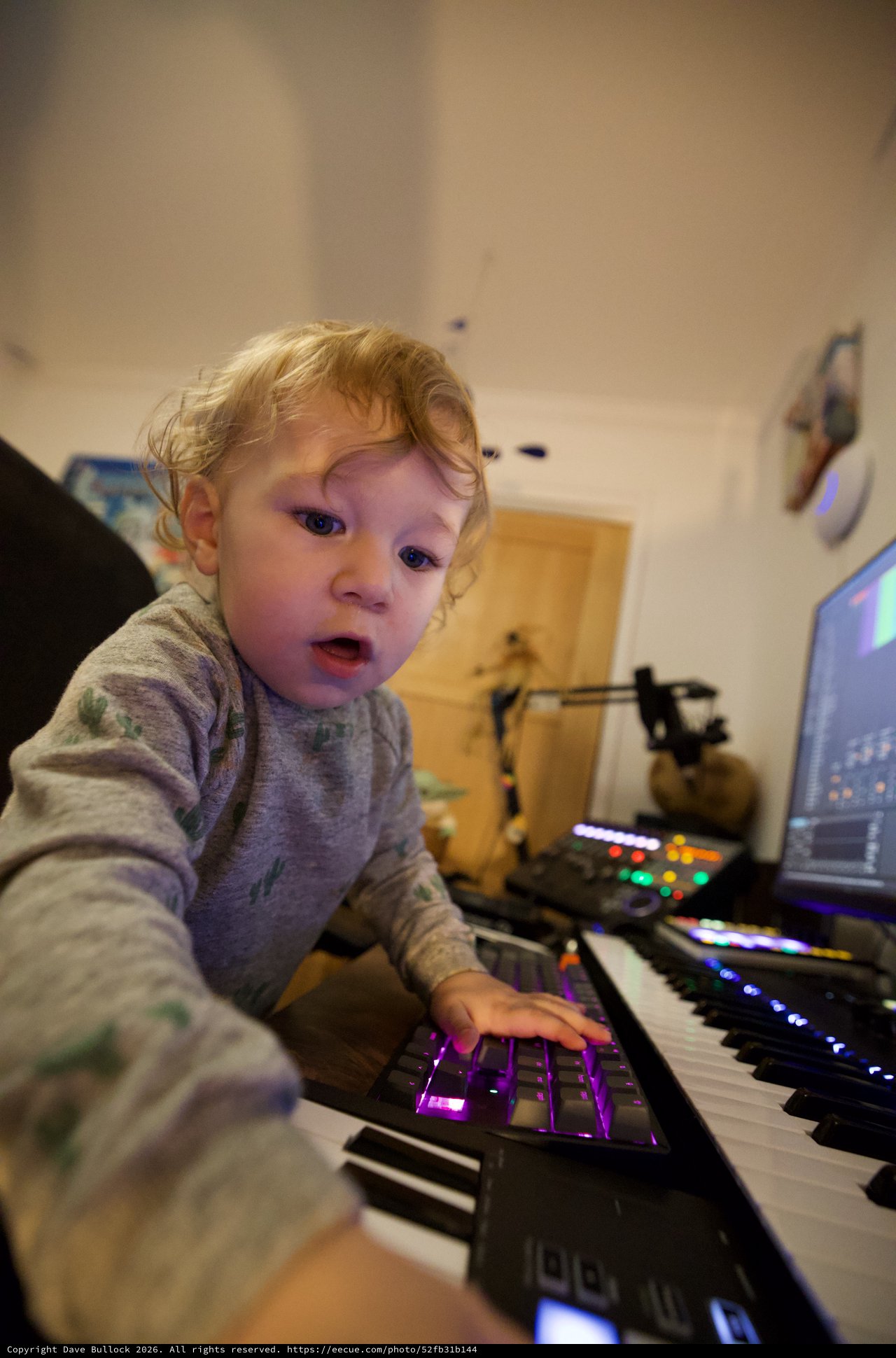 Young Child Exploring Music Production Equipment at Night