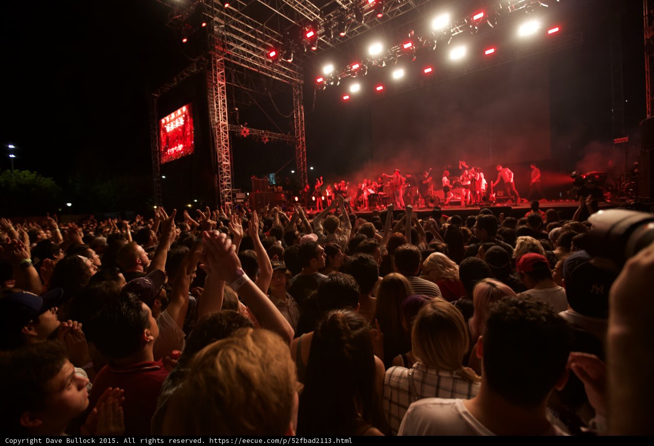 Belle and Sebastian Wide Stage Arm Raised Fan Red Lighting Ensemble Video Screen Crowd