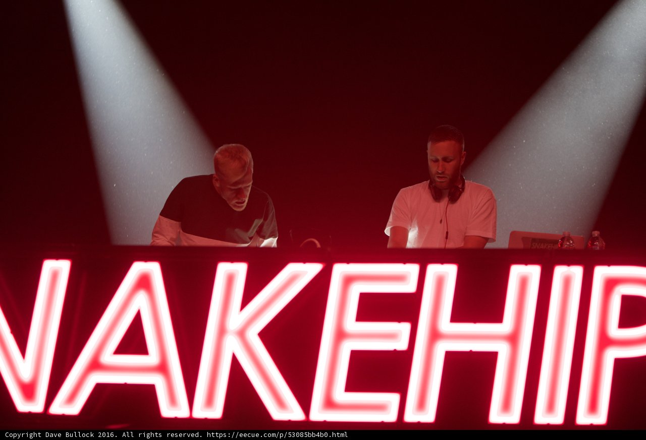 Two Men Spotlit by Wakehip Neon Sign