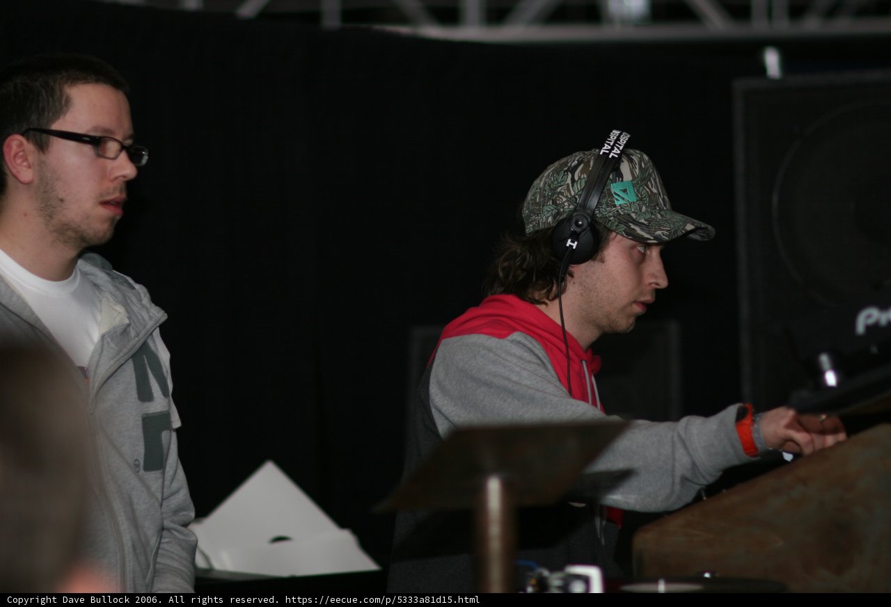 The Funky Beat Creators Caption: Two music producers in their studio, wearing headphones and caps, working on creating the perfect sound for their latest funk album.
