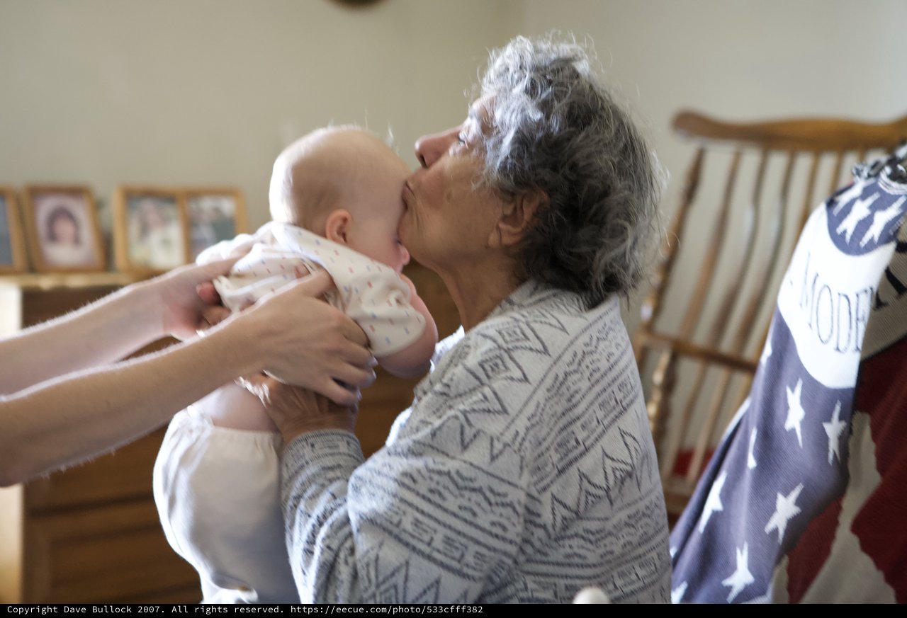 Grandmother's First Kiss with Newborn Grandchild