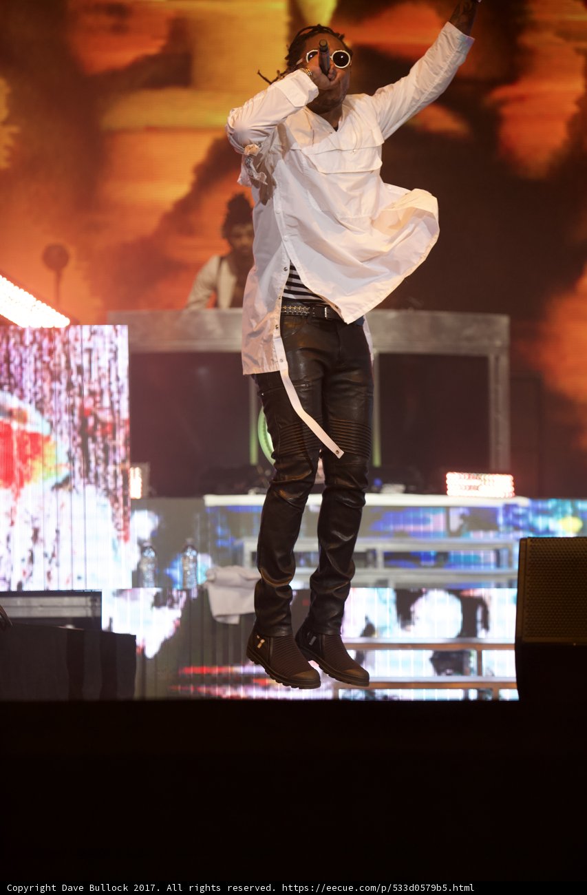 Man on Stage in White Shirt and Black Pants