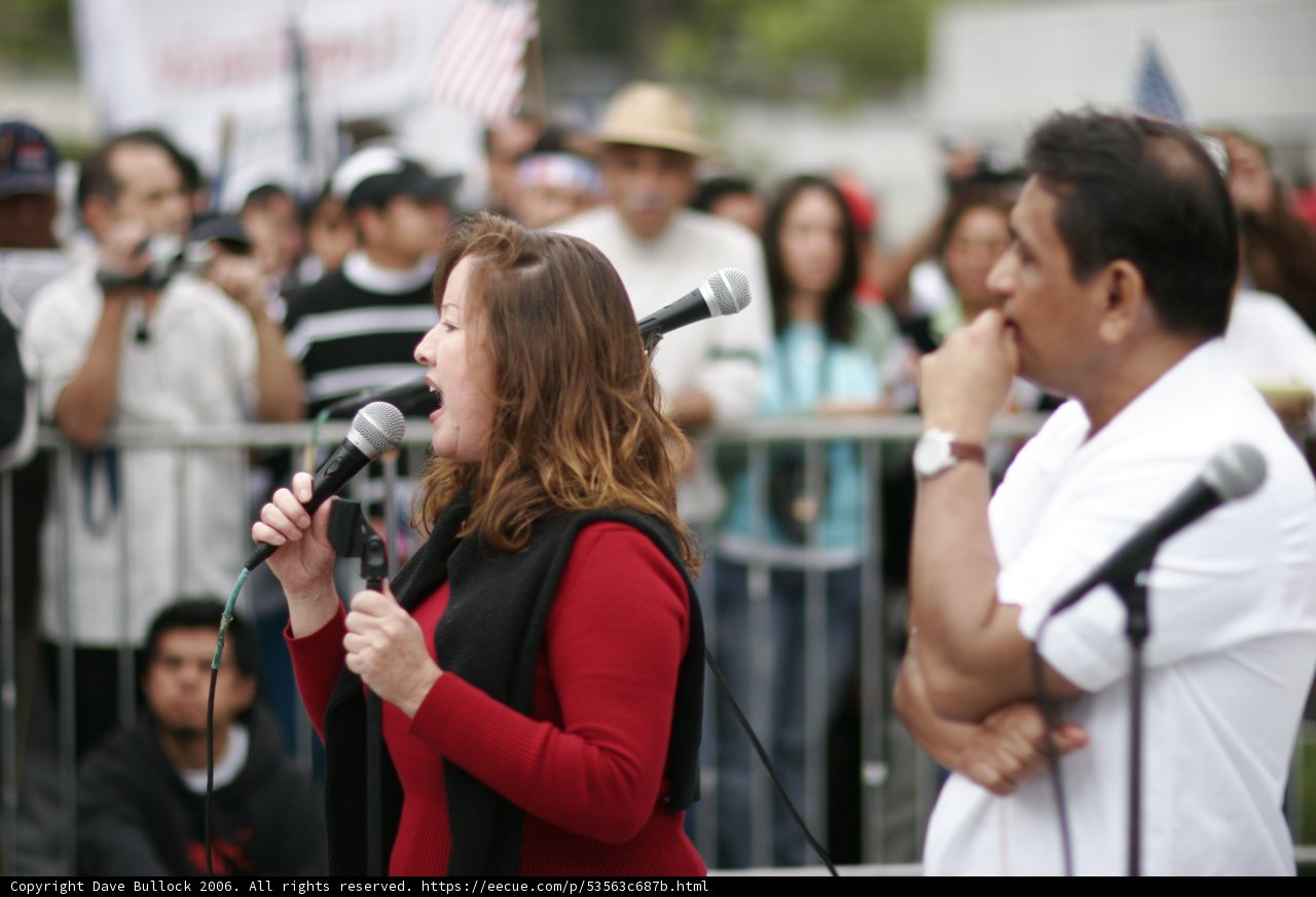 Student Activist Takes the Mic Caption: A powerful speech from a young student activist at the front of a crowded protest.