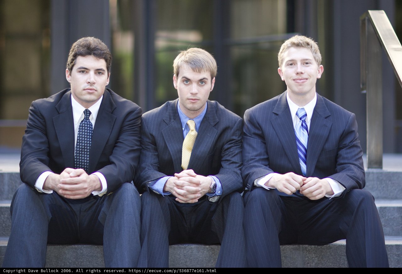 Three Men in Suits Strike a Pose on the Stairs