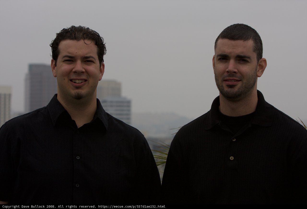 Two Smiling Men Posed Outside a Building