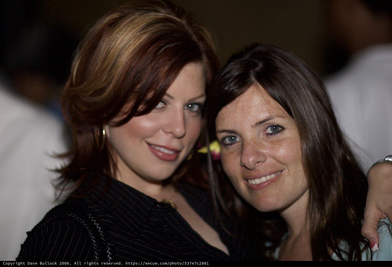 Two Women Smiling Together at Evening Event
