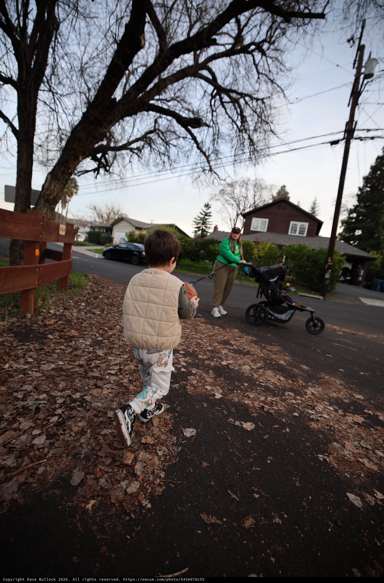 Child Running Towards Parent with Stroller on Suburban Street