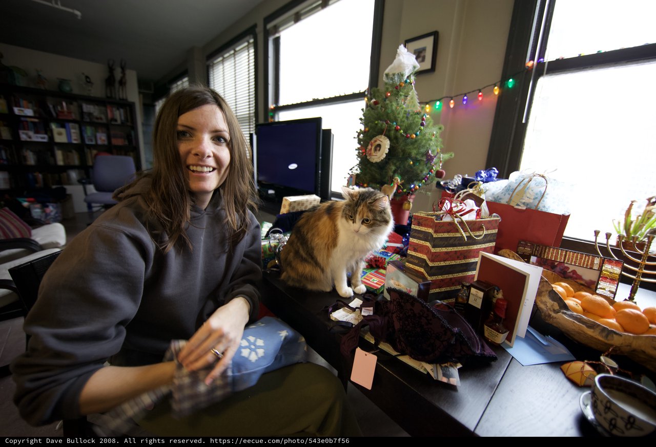 Holiday Joy: Woman and Cat Amid Christmas Gifts