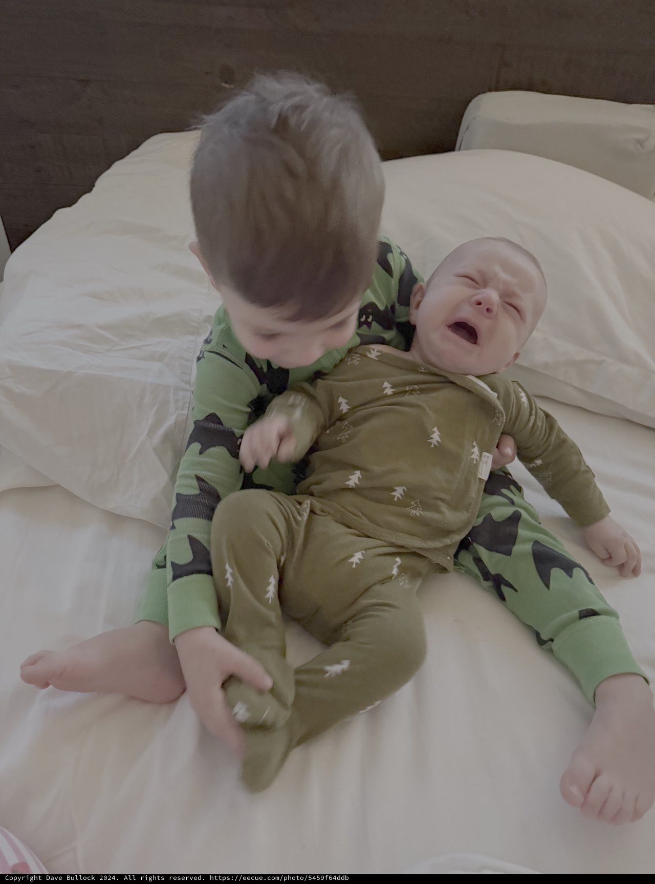 Tender Sibling Moment on White Bedding