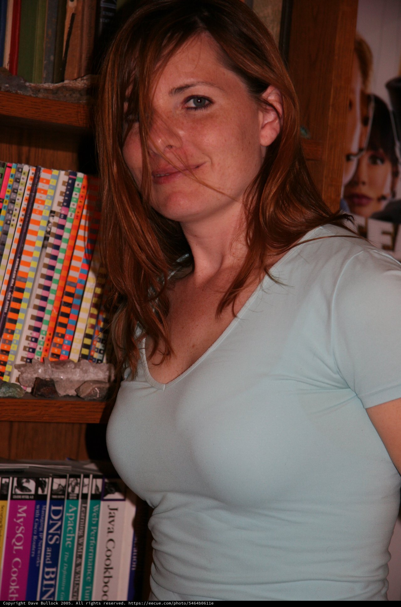 Redheaded Woman Smiling Among Technical Books