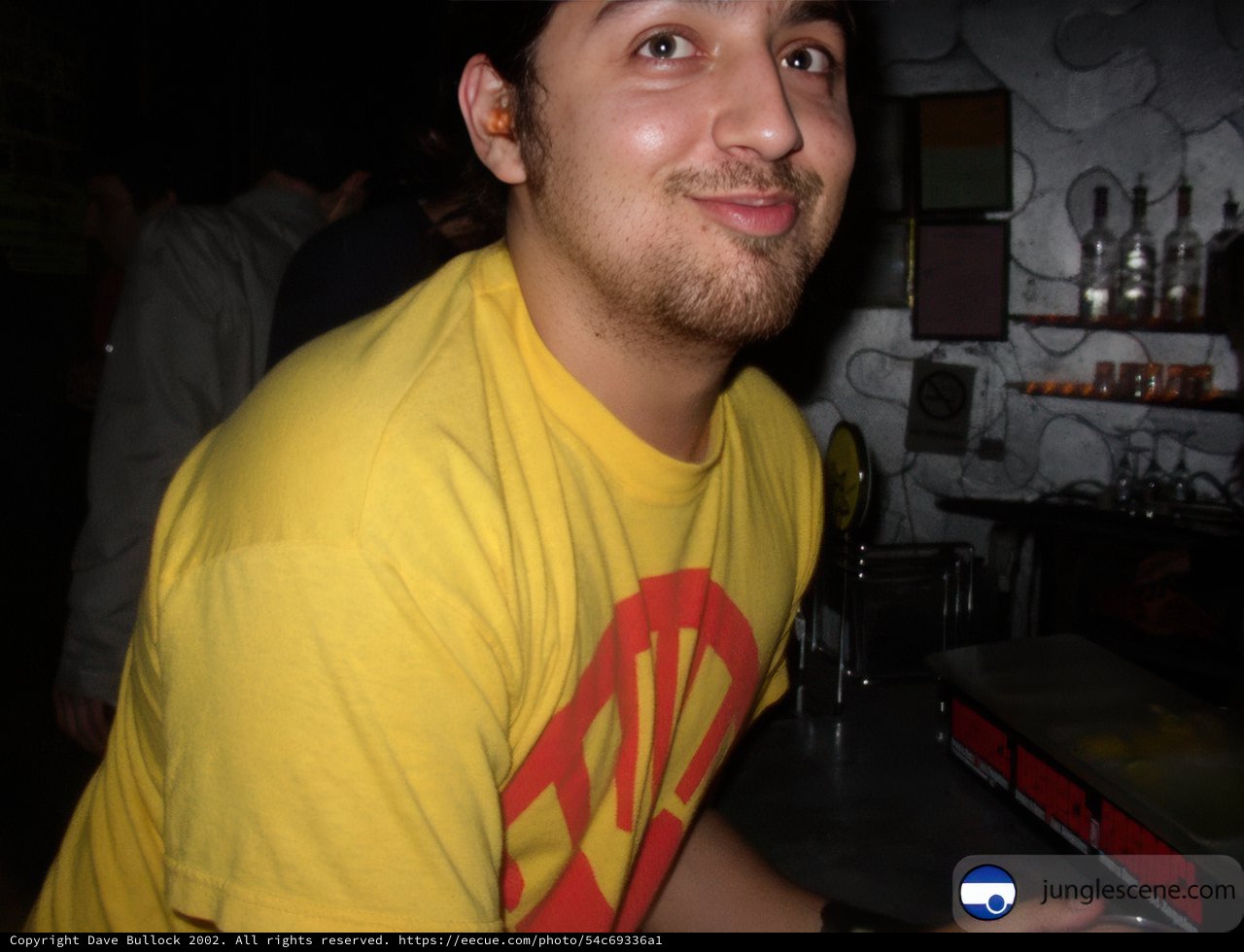 Yellow-shirted man enjoys a night out at the pub