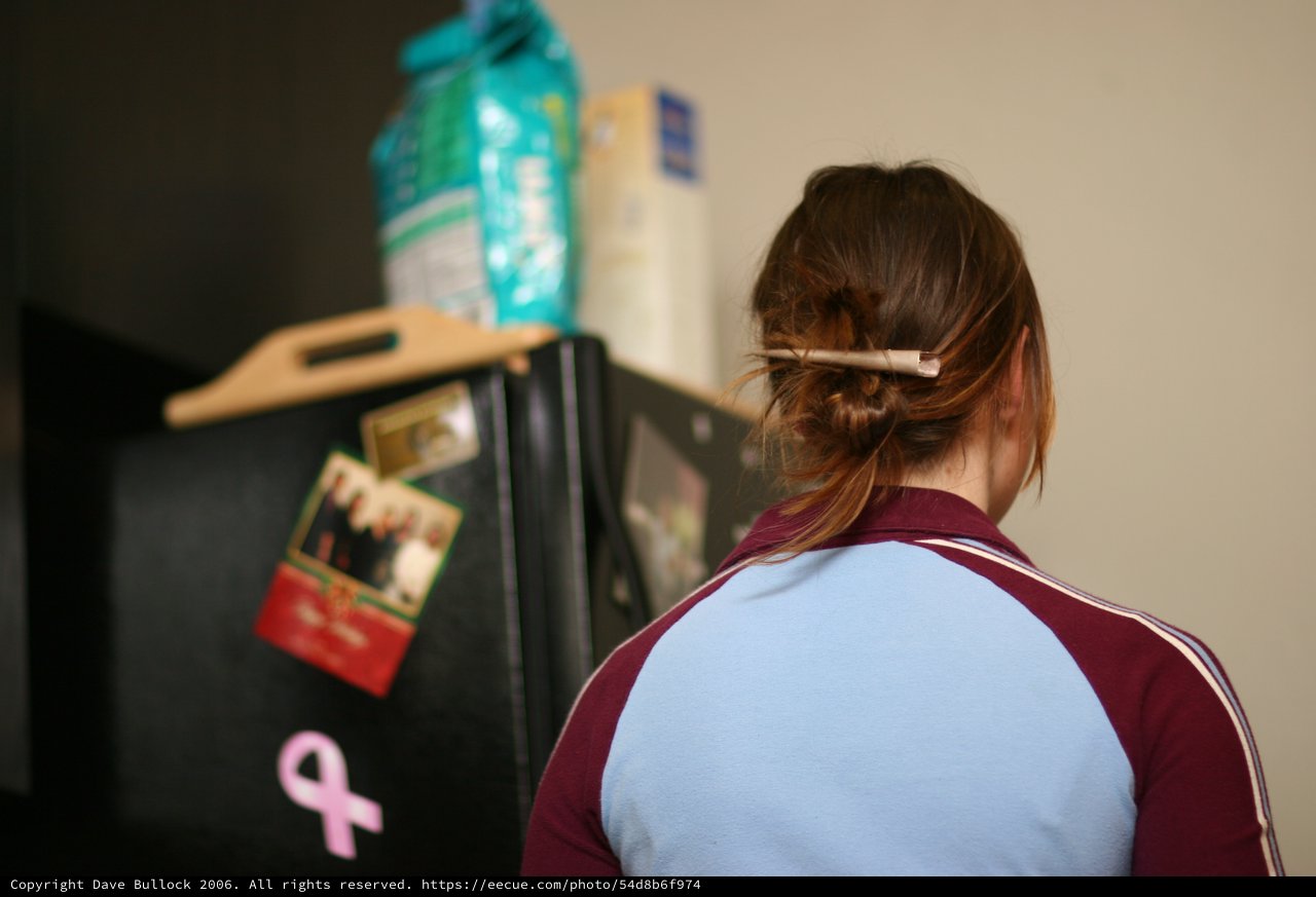 Woman Looking Into Black Refrigerator in Kitchen
