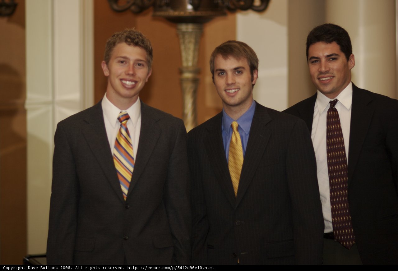 Three Men in Black Suits Pose for a Photo