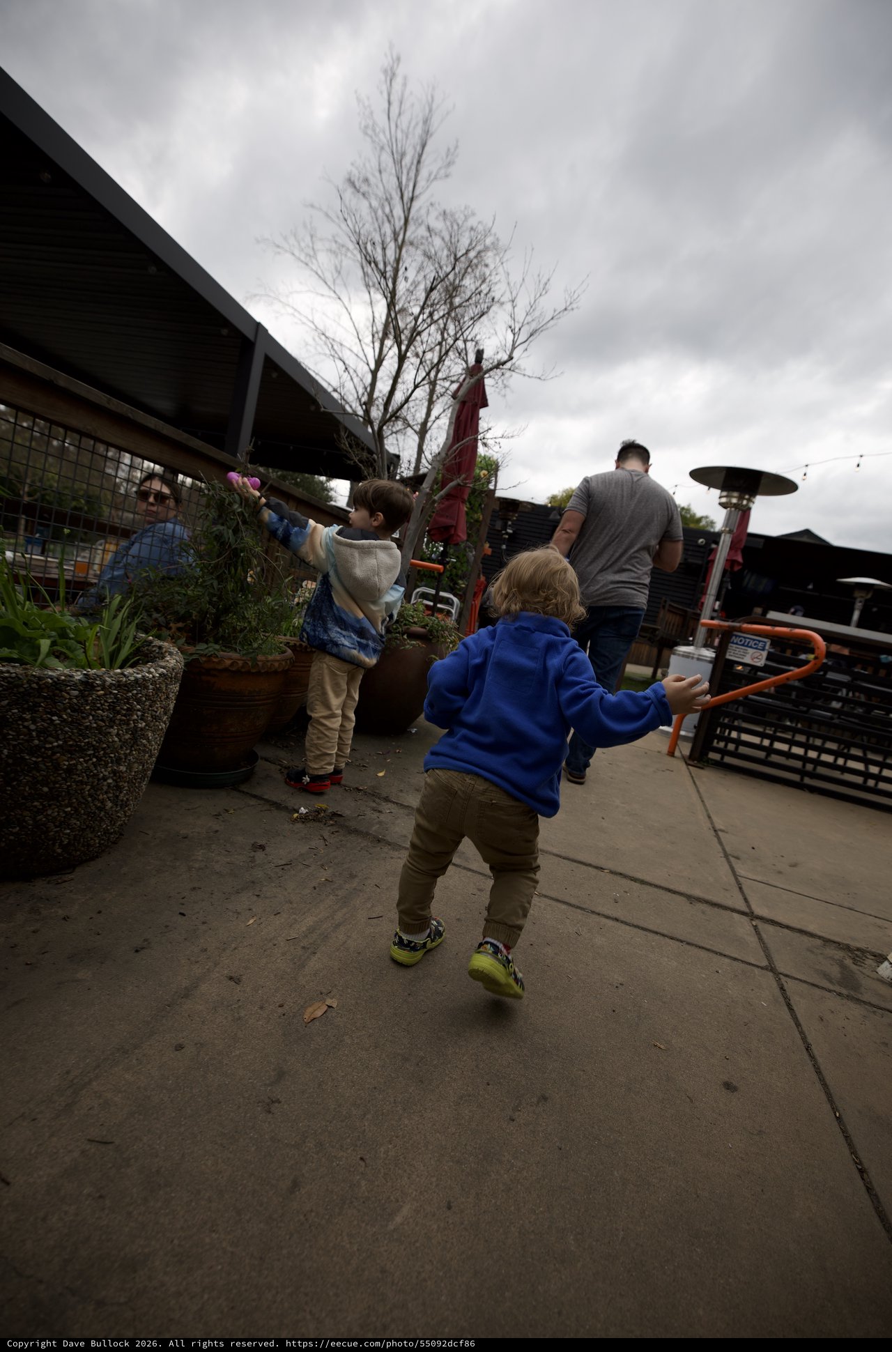 Children Playing on Restaurant Patio Under Cloudy Skies
