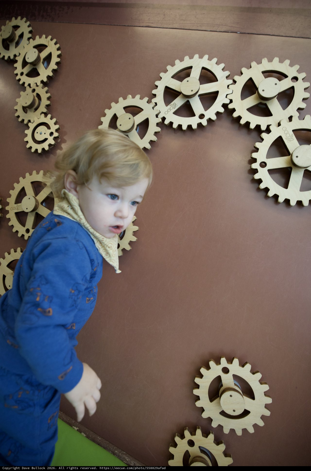 Toddler Exploring Interactive Gear Wall Display
