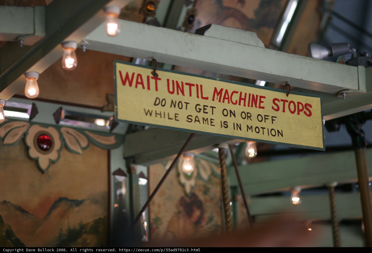 Wait Until Machine Stops" Sign in Industrial Cafeteria