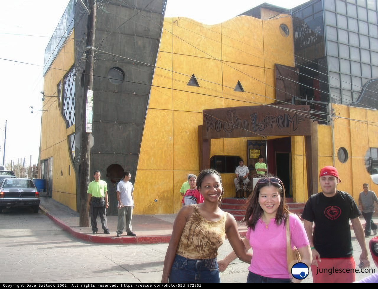 Three People Pose in Front of Yellow Ensenada Building