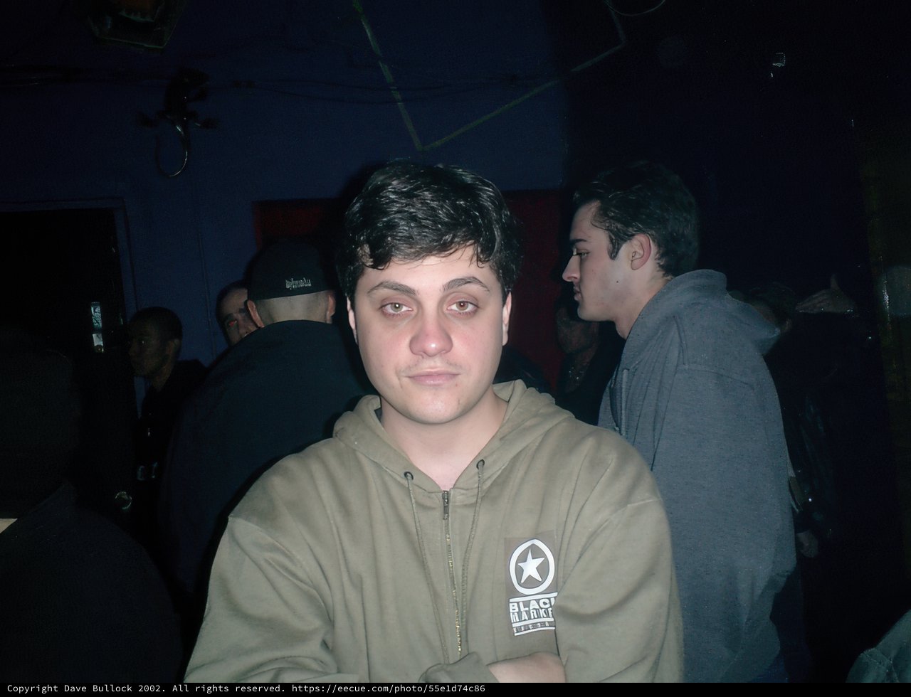 Urban Portrait: Man in Hoodie in a Crowded Room