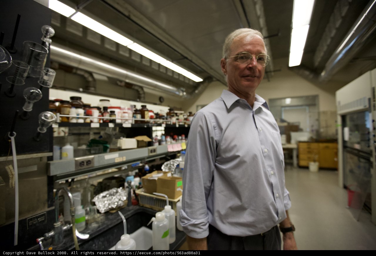 Lab Coat Man Examines Shelf of Nanomachines