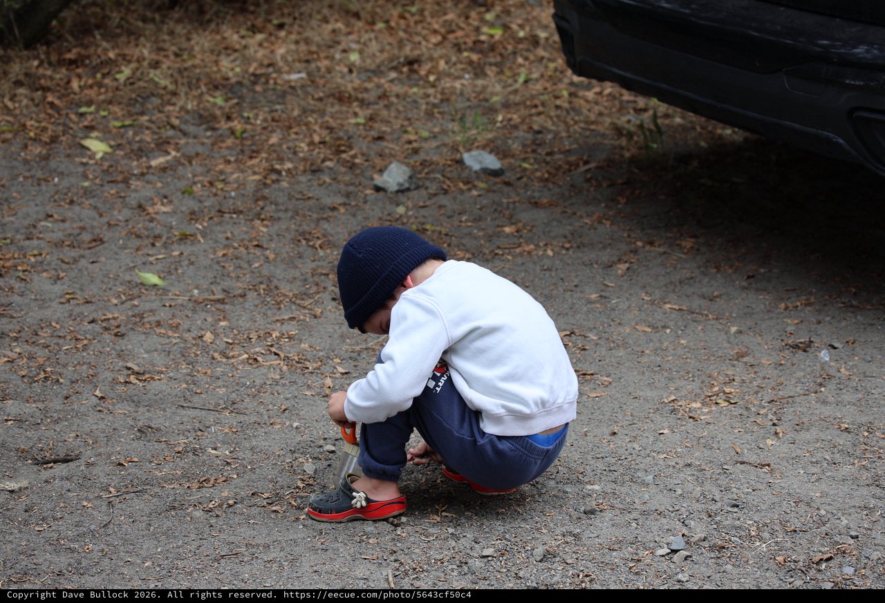Young Boy Explores the Ground at Campsite