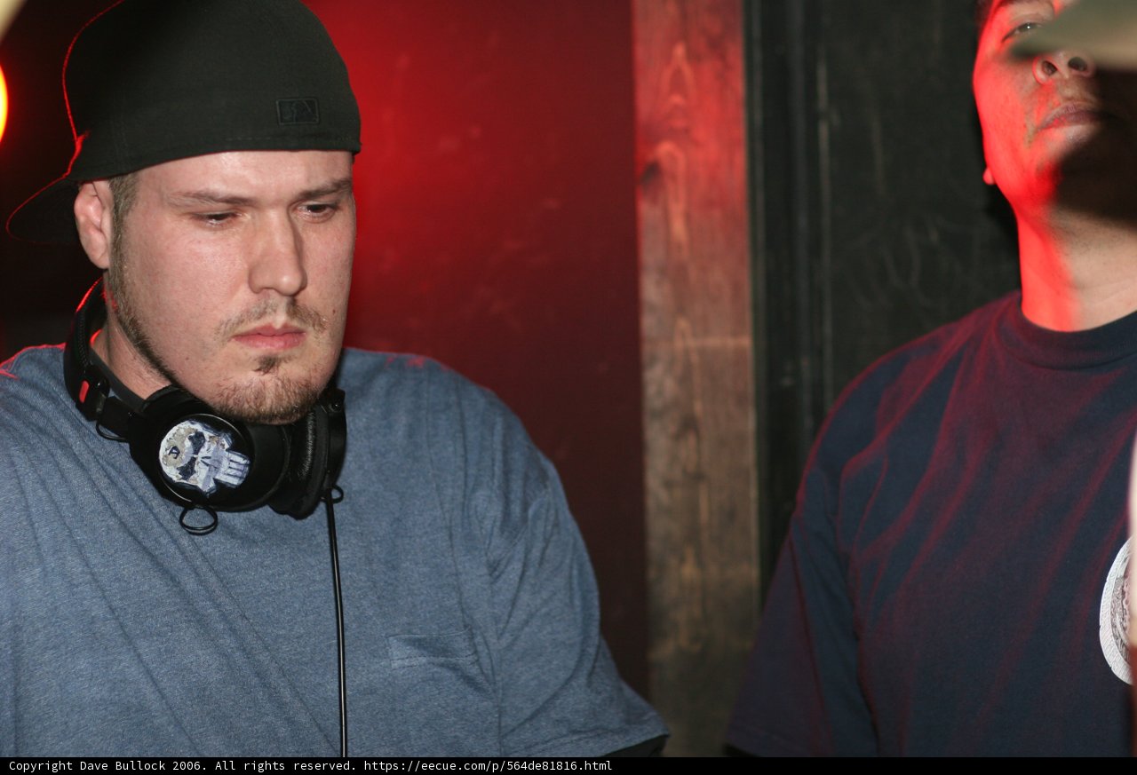 Black hat deejay performs with headphones