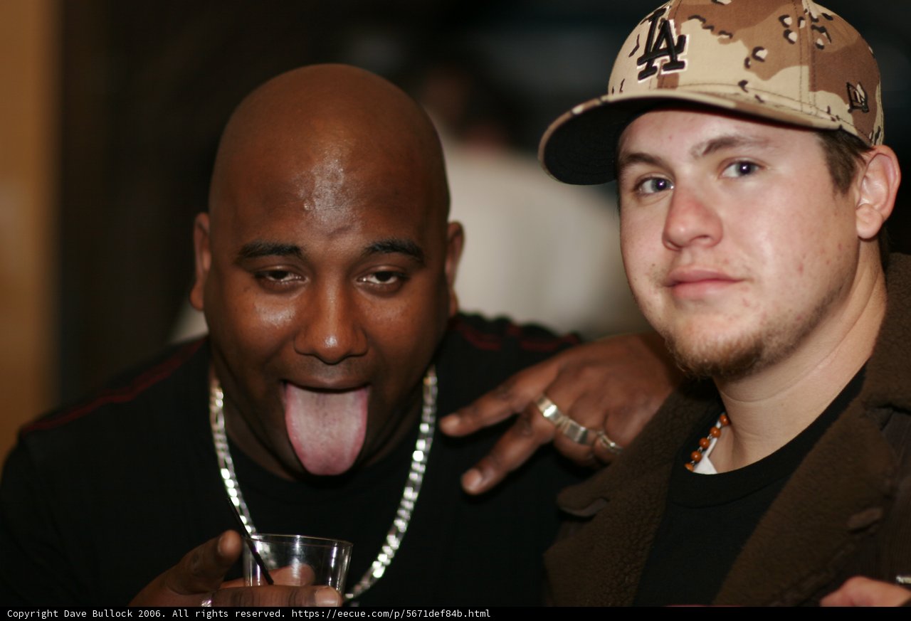 Brown Jacketed Man Enjoying a Drink with Friend
