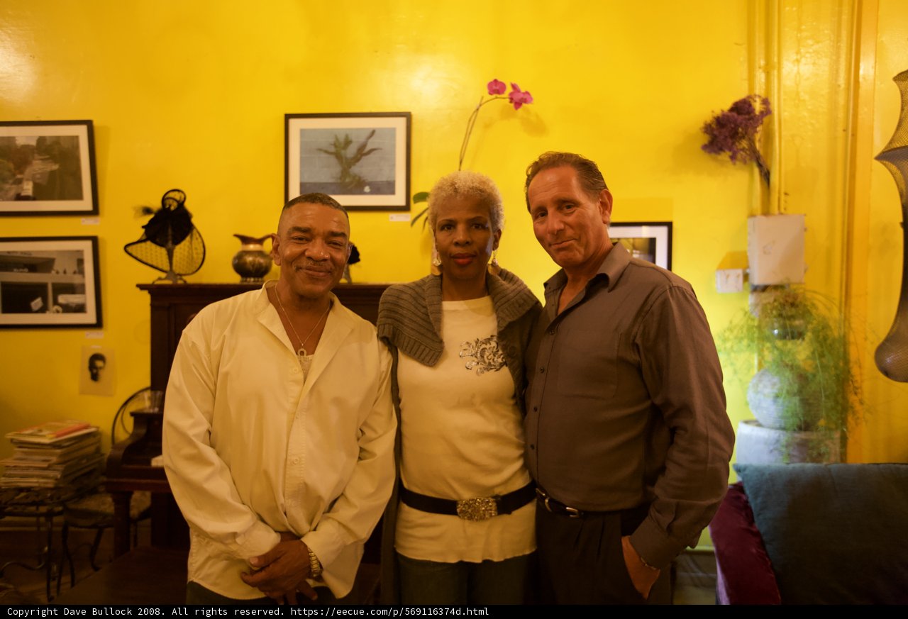 Three Men Admire Art in a Yellow Room