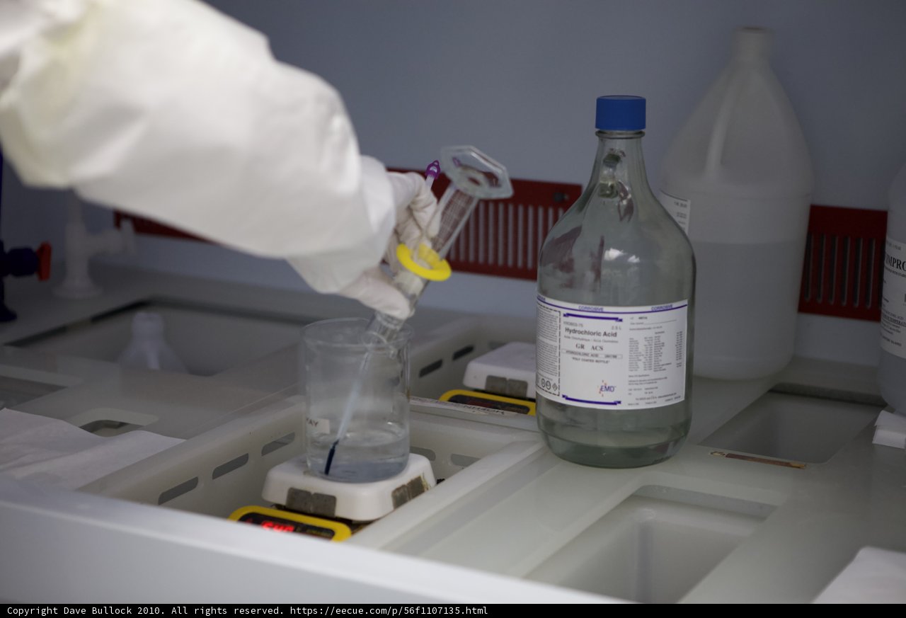 Lab Coated Scientist Holds Bottle